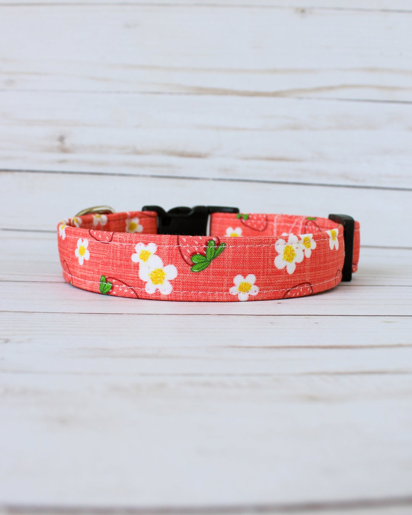 Floral-patterned dog collar on a wooden surface