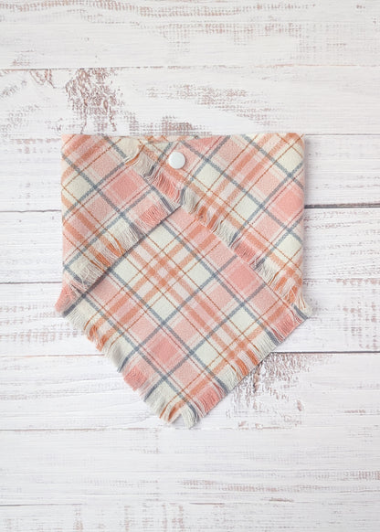 Plaid flannel bandana  with pink and light gray pattern on a wooden surface