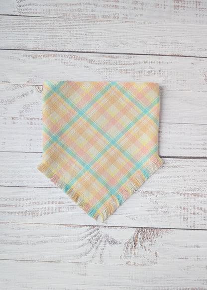 Pastel plaid flannel bandana in yellow, light blue, pink, on a wooden surface