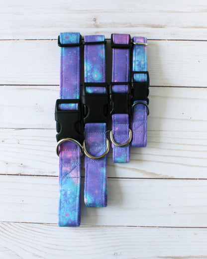 Set of galaxy-themed dog collars on a light wooden surface