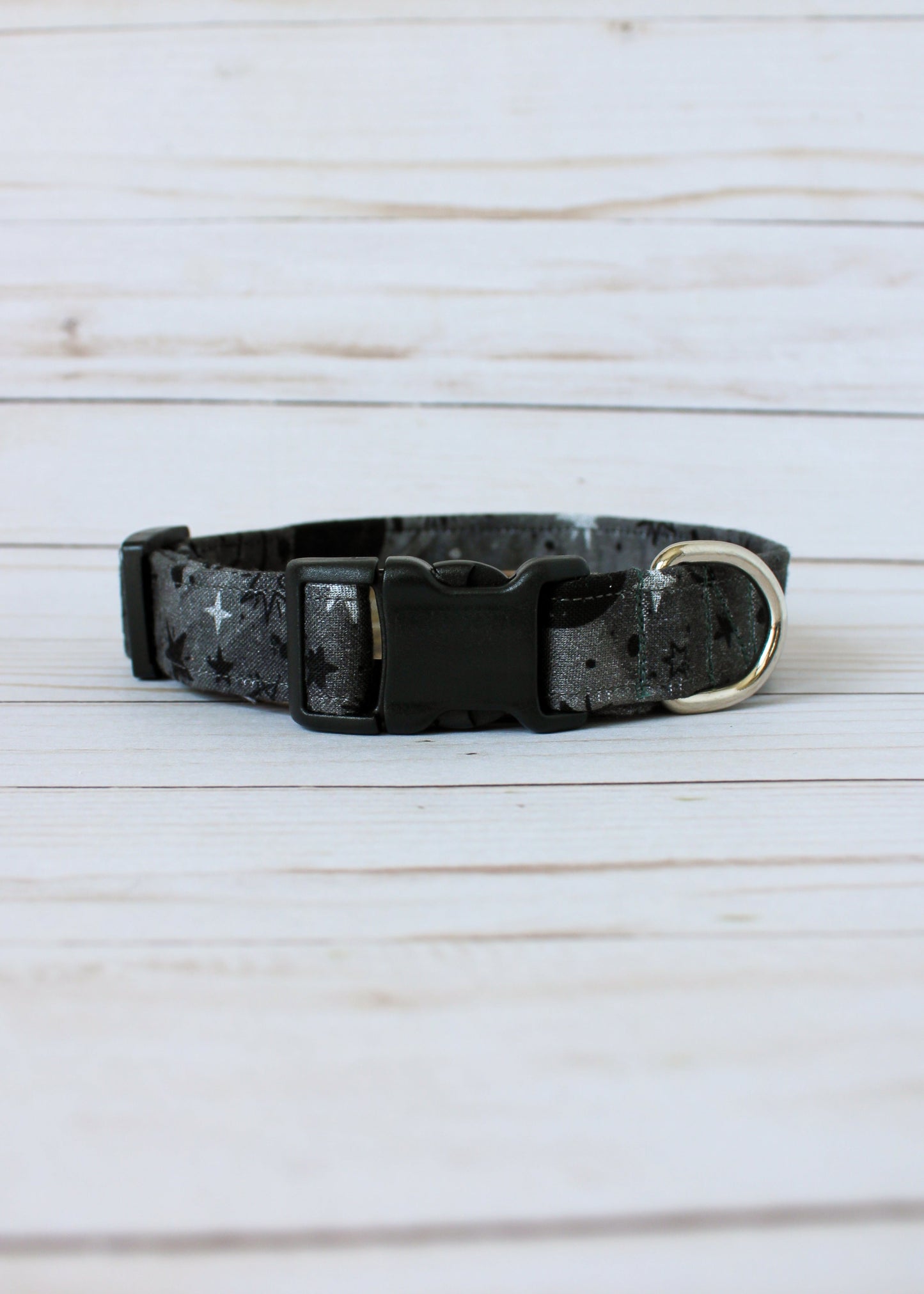 Black and gray patterned dog collar on a light wooden surface
