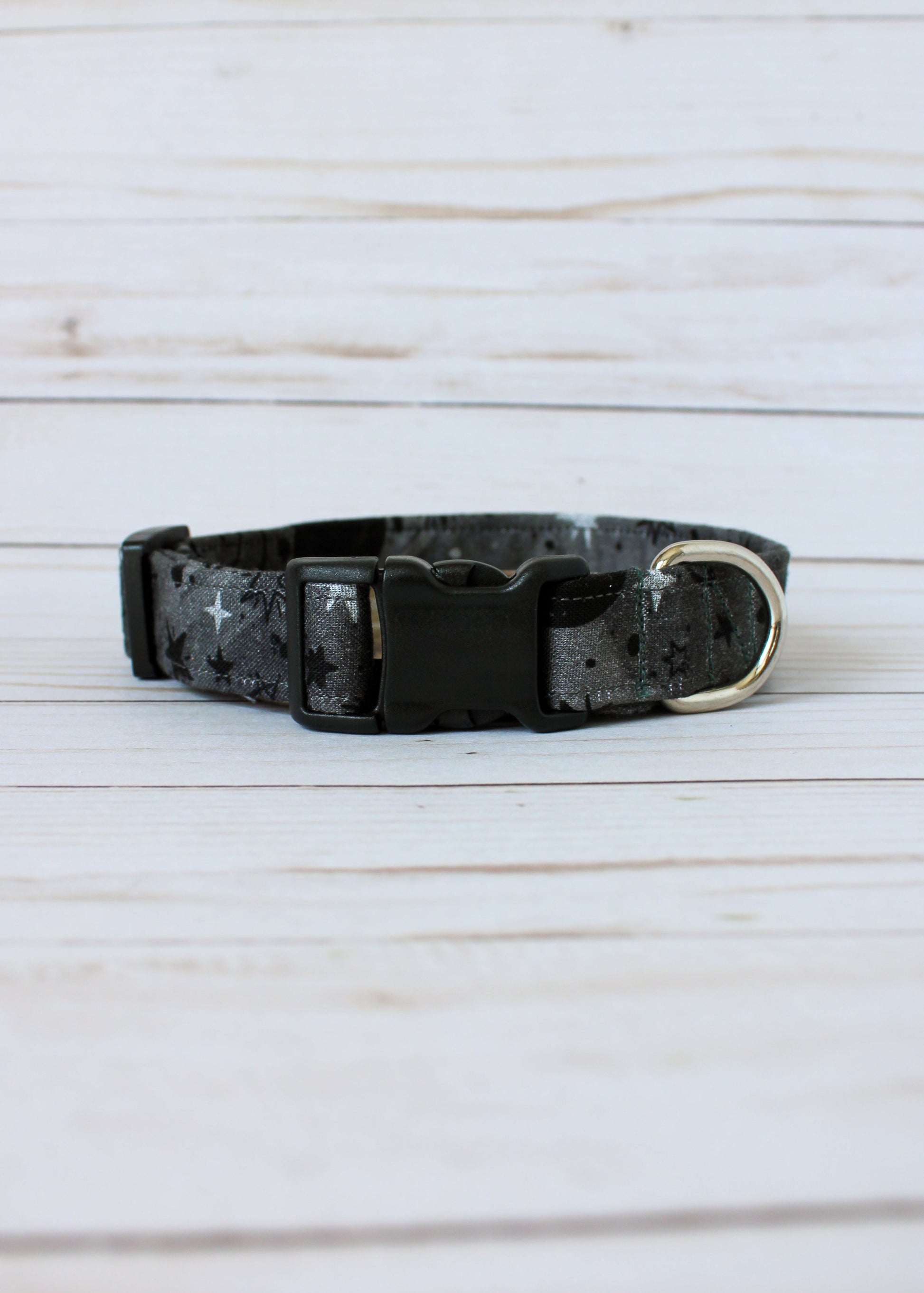 Black and gray patterned dog collar on a light wooden surface