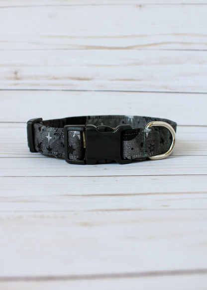 Black and gray patterned dog collar on a light wooden surface