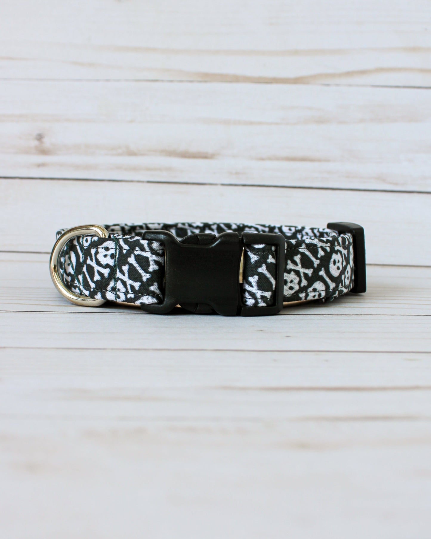 Black dog collar with white pattern on a light wooden surface