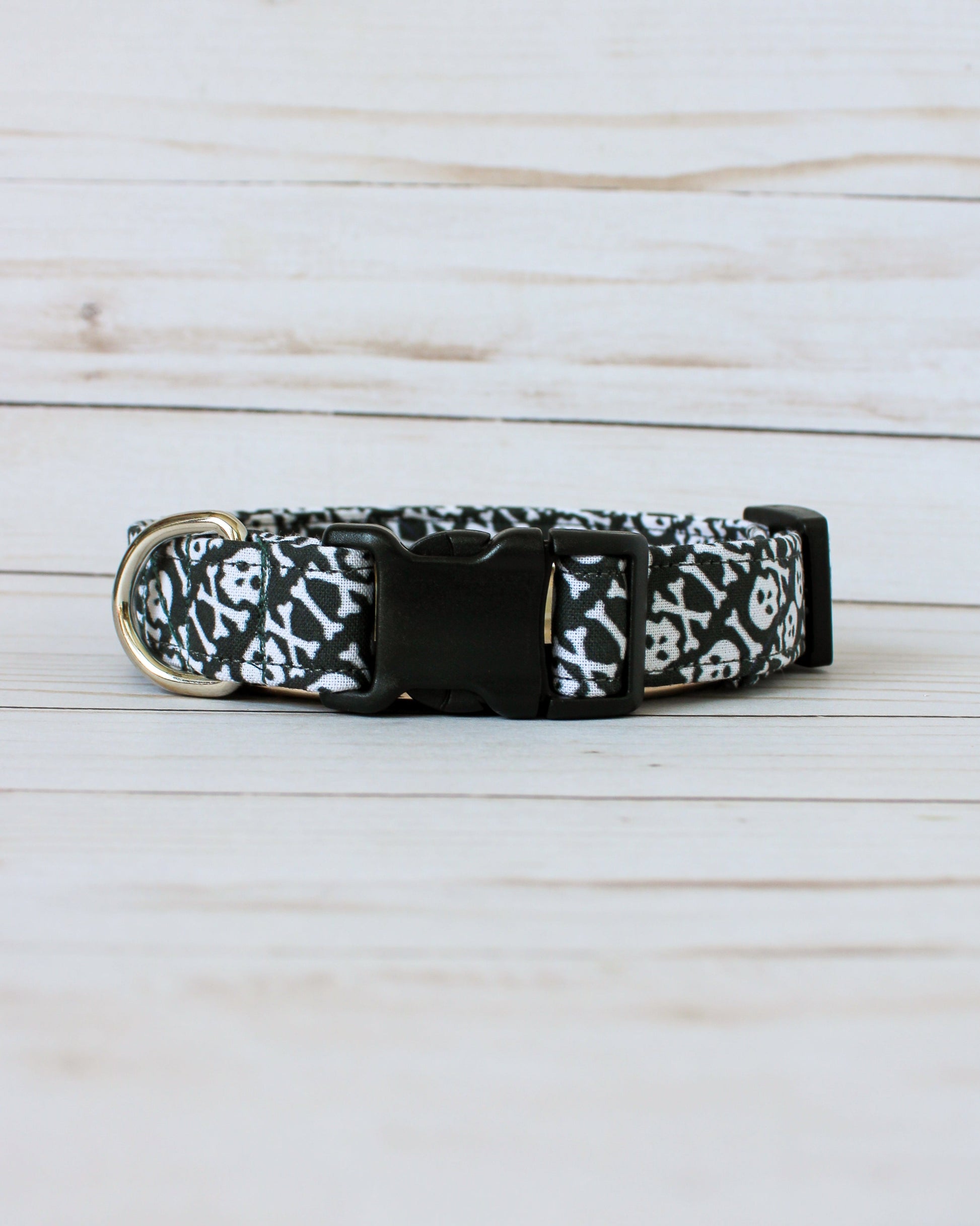 Black dog collar with white pattern on a light wooden surface