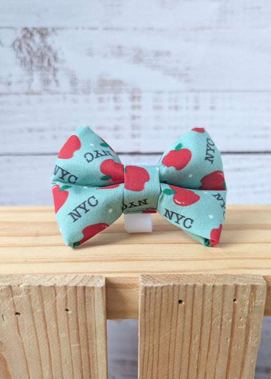 Dog bow tie with a red apple and "NYC" repeating pattern