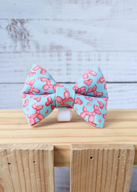 Fabric dog bow tie with a pink balloon animal pattern on a turquoise background