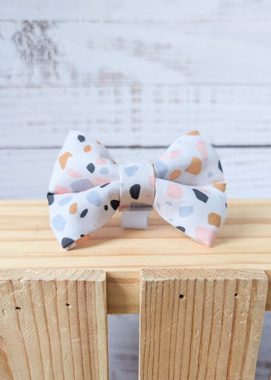 Dog bow tie with a terazzo pattern on a cream colored background