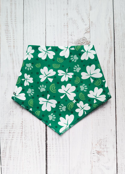 Green bandana with white shamrock patterns on a wooden surface