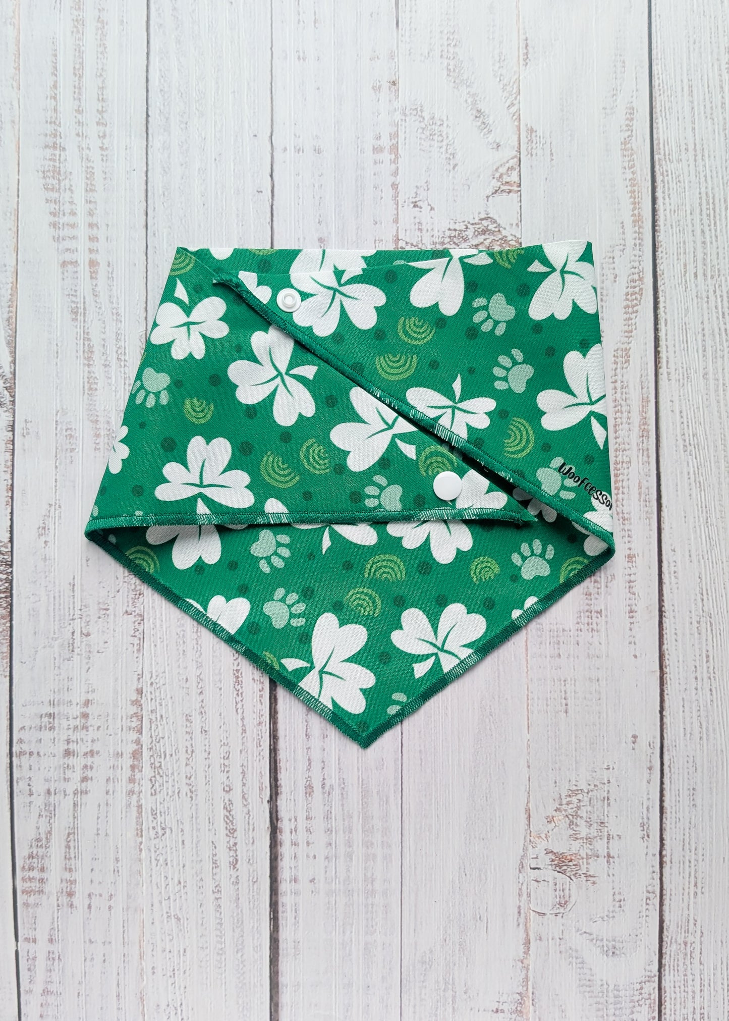Green bandana with white shamrock patterns on a wooden surface