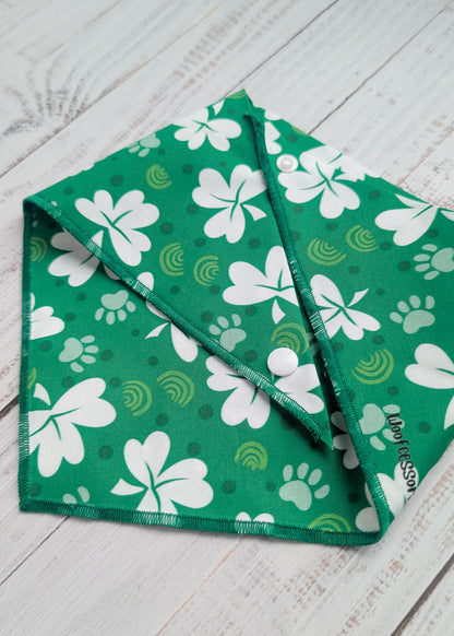 Green bandana with white shamrock patterns on a wooden surface