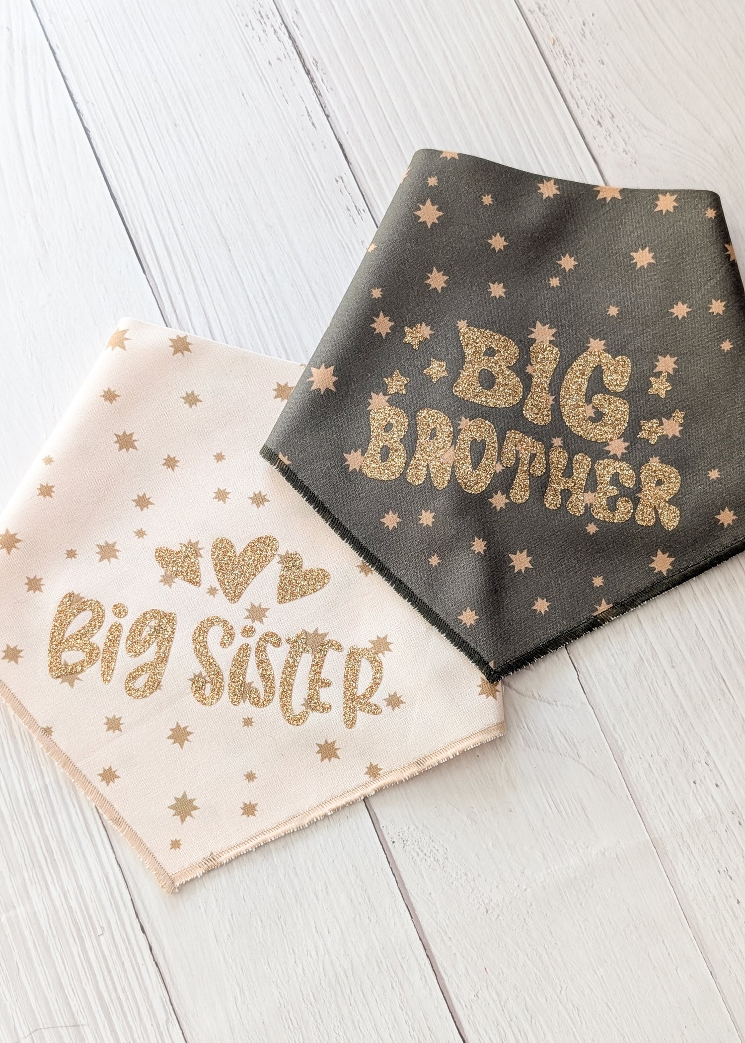 Two bandanas with 'Big Brother' and 'Big Sister' text on a wooden surface