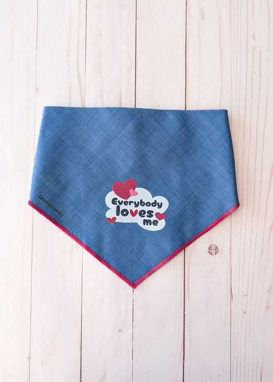 Denim bandana with a quote saying "everybody loves me" on light wood background