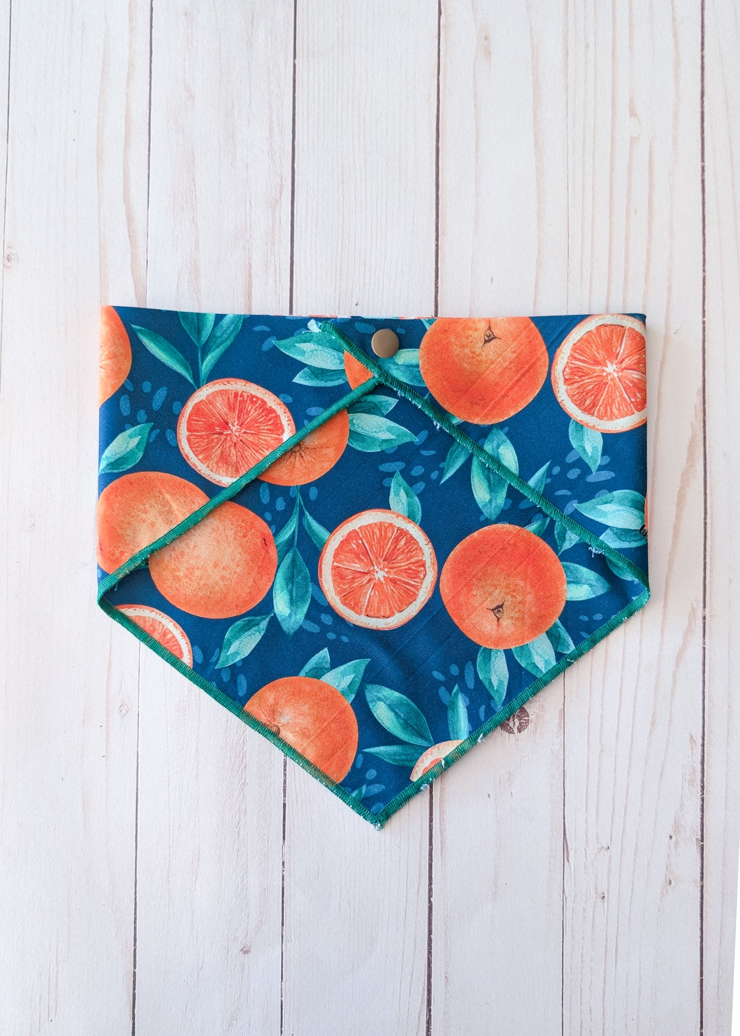 Fruit-themed bandana with oranges and leaves on a wooden surface