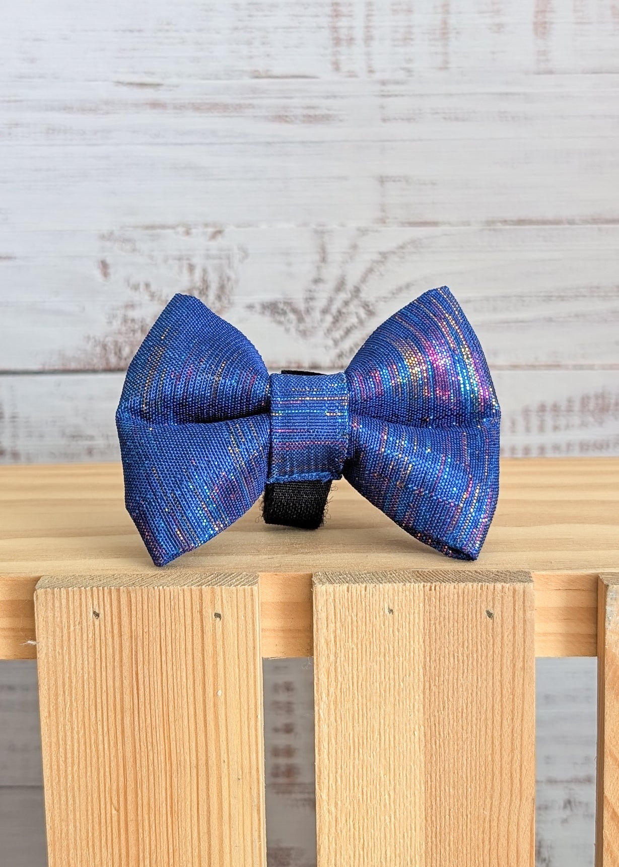 Blue plaid bow tie on a wooden surface with a light wooden background
