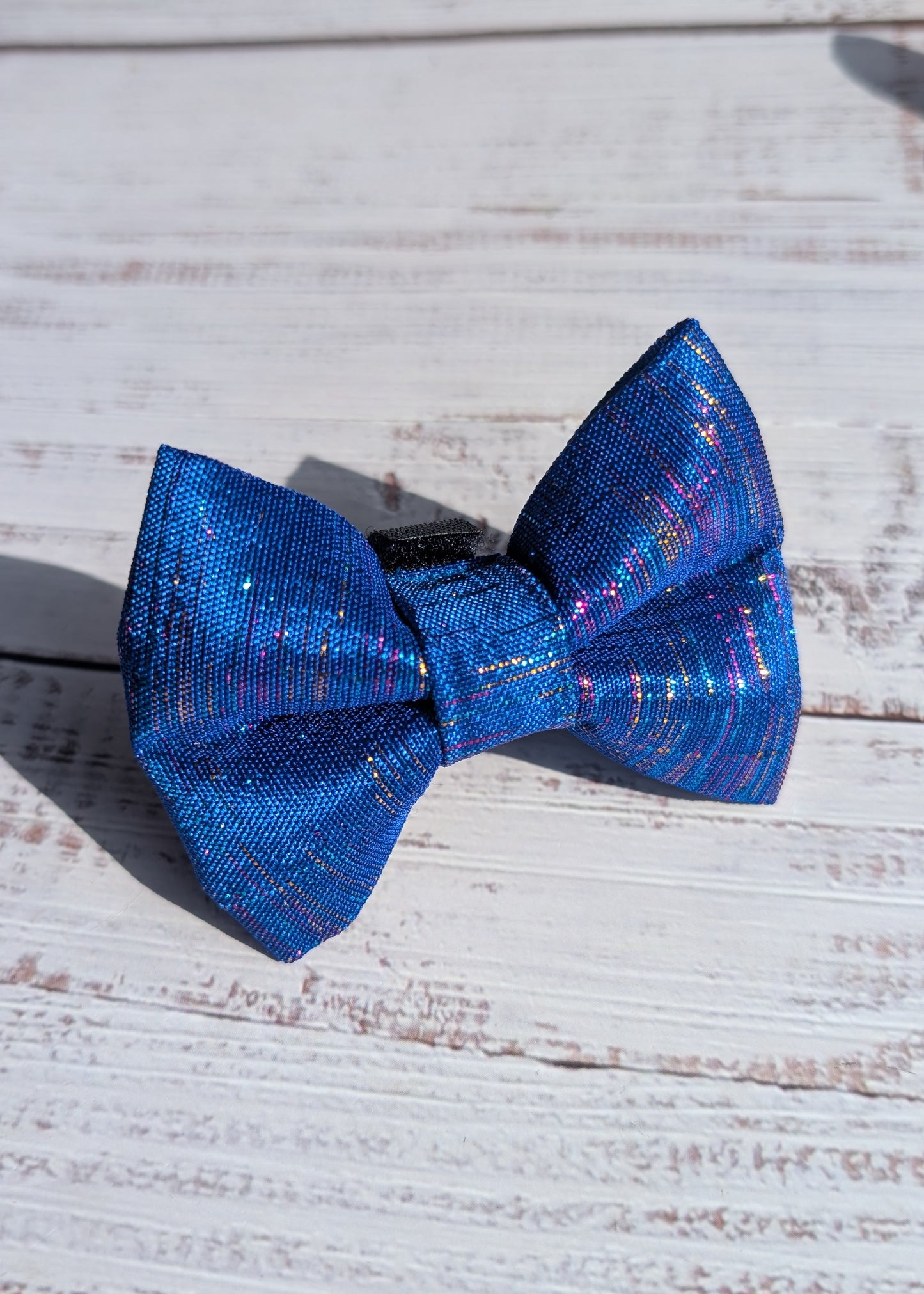 Blue metallic bow tie on a wooden surface