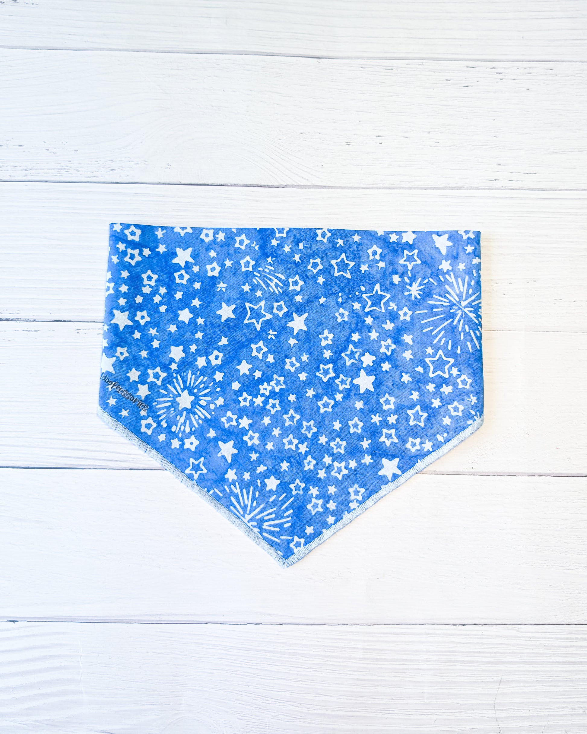 Blue bandana with white star pattern on a light wooden surface