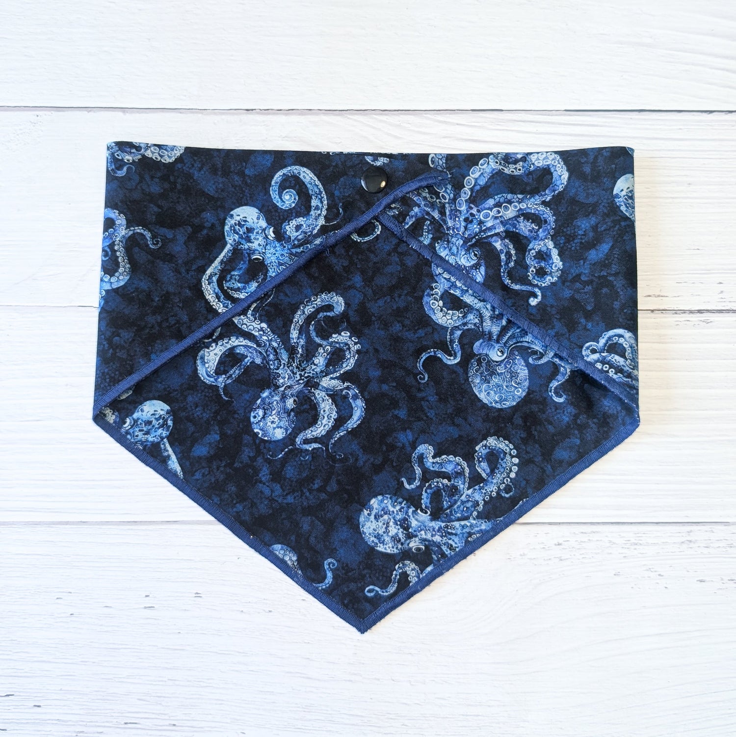 Blue bandana with white octopus pattern on a white wooden surface