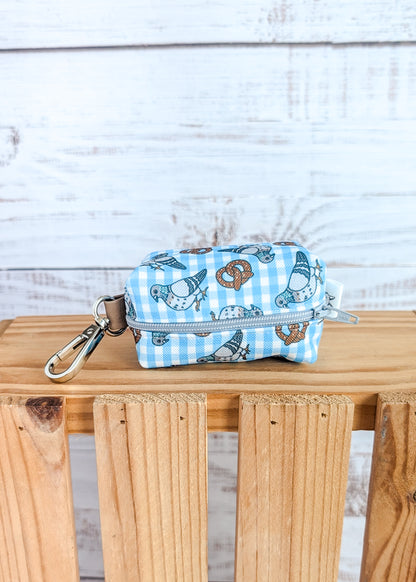 Small pouch with pigeon and pretzel design on a wooden surface against a light wooden panel background