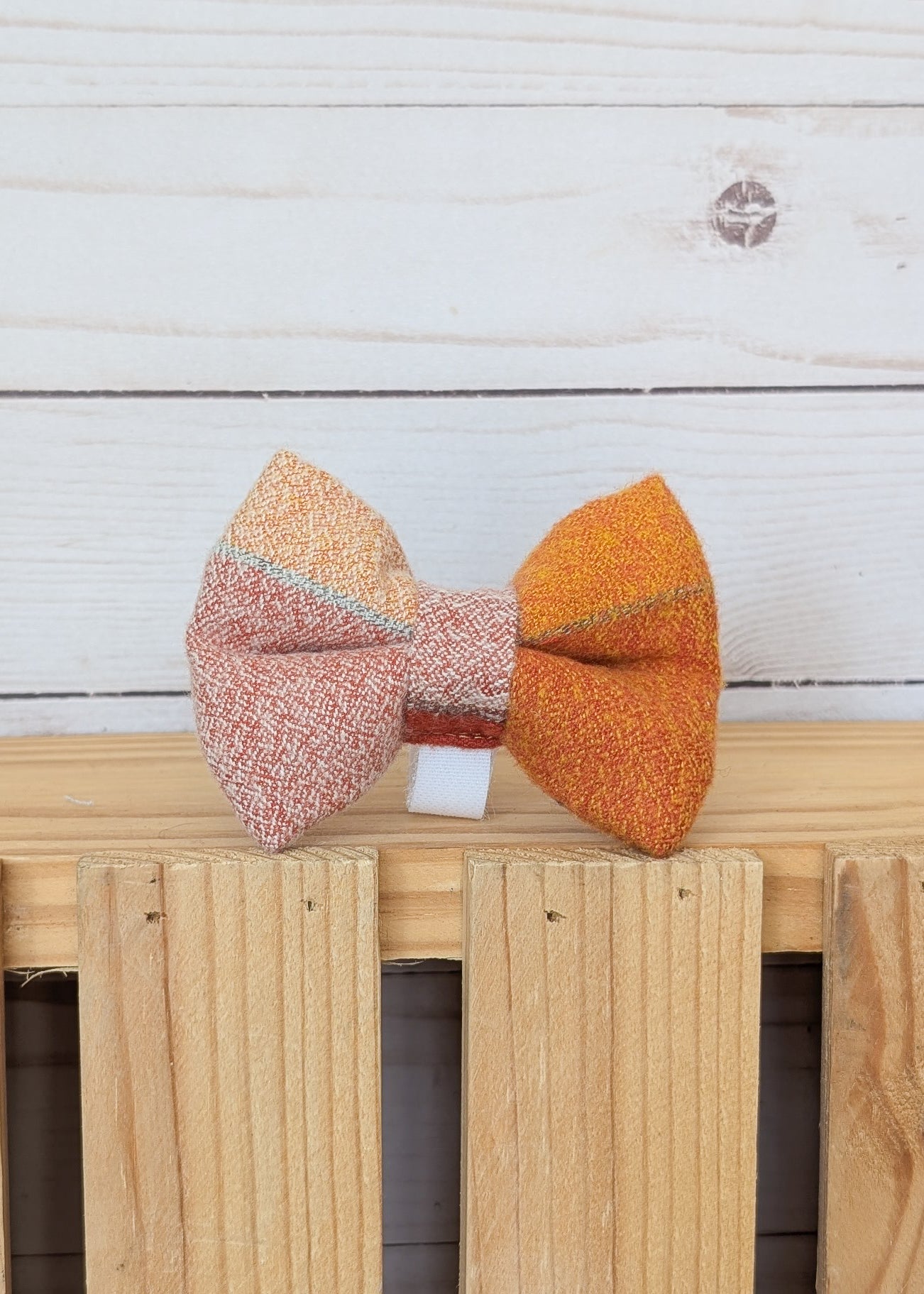 A handmade fabric bow tie with a yellowish brown tan flannel plaid design