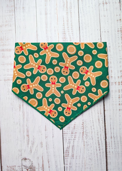 Green bandana with gingerbread man pattern on a wooden surface