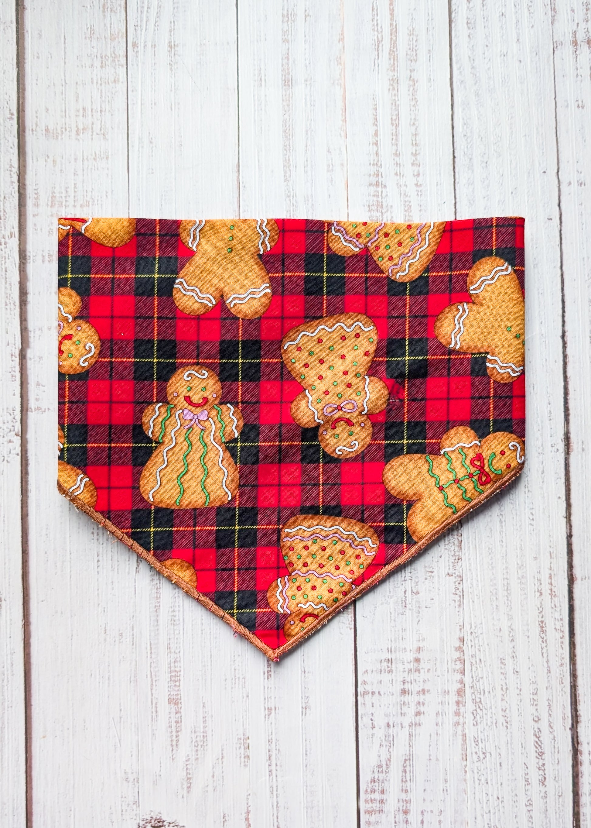 Plaid bandana with gingerbread men design on a wooden surface