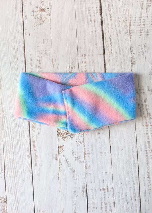 Pastel tie-dye fleece dog scarf on a wooden surface front view